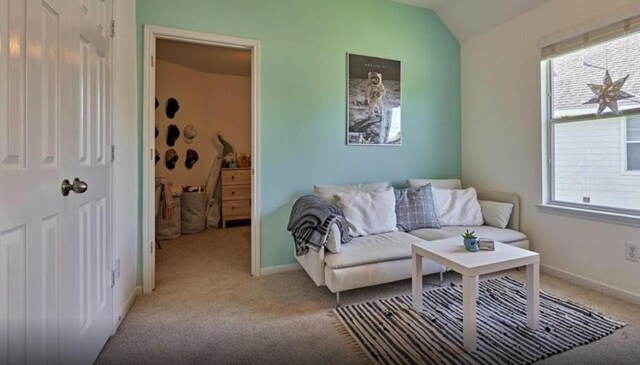 carpeted living room featuring a healthy amount of sunlight, baseboards, and lofted ceiling