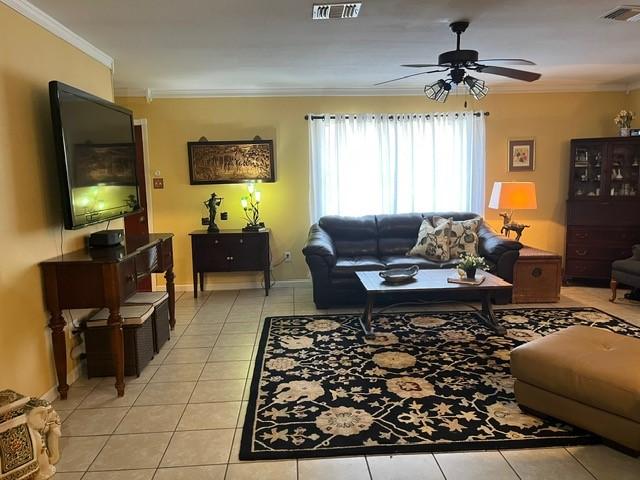 living room with crown molding, a ceiling fan, light tile patterned flooring, and visible vents