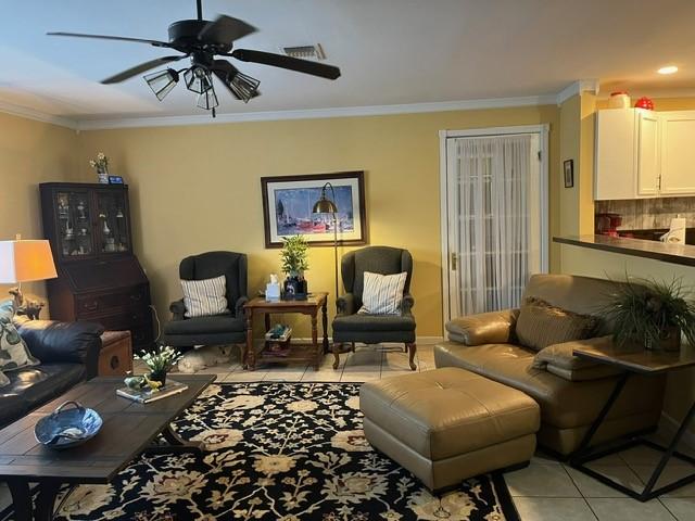 living room with crown molding, ceiling fan, light tile patterned flooring, and visible vents