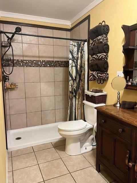 full bathroom with tile patterned flooring, ornamental molding, toilet, and tiled shower