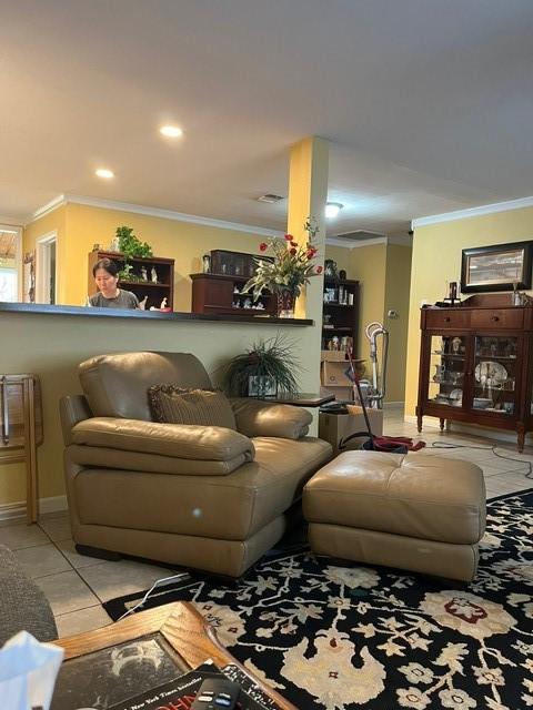 living room featuring crown molding, baseboards, and tile patterned flooring