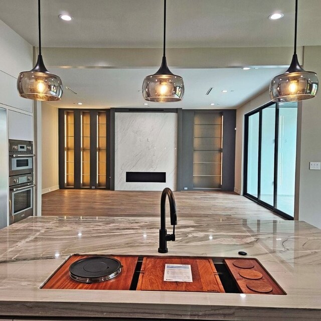 kitchen featuring recessed lighting, double oven, and decorative light fixtures