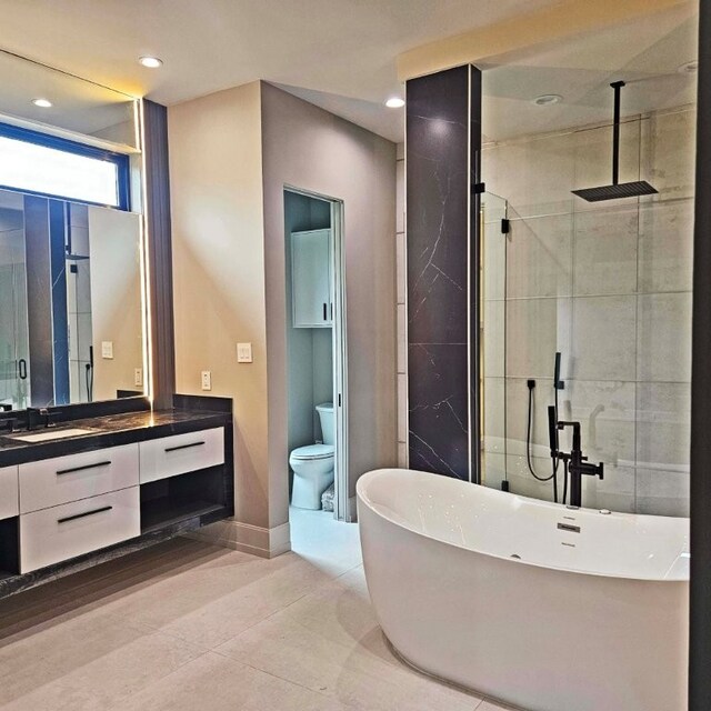 bathroom featuring a freestanding bath, a shower stall, vanity, baseboards, and recessed lighting