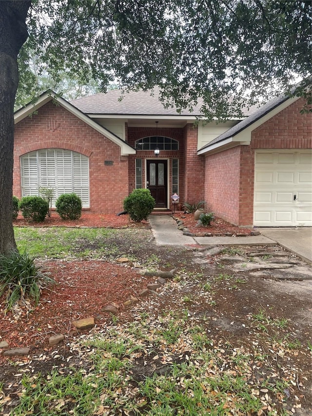 property entrance with brick siding, a garage, and french doors