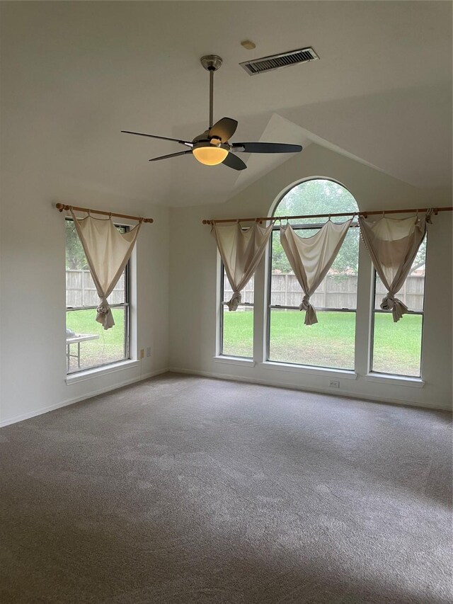 unfurnished room featuring visible vents, plenty of natural light, carpet floors, and lofted ceiling