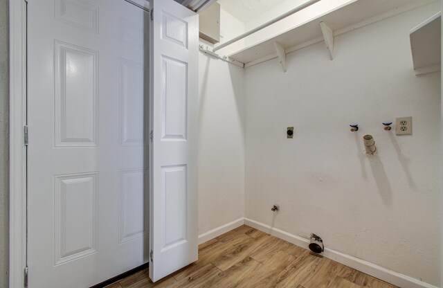 washroom featuring laundry area, light wood-style floors, baseboards, gas dryer hookup, and hookup for an electric dryer