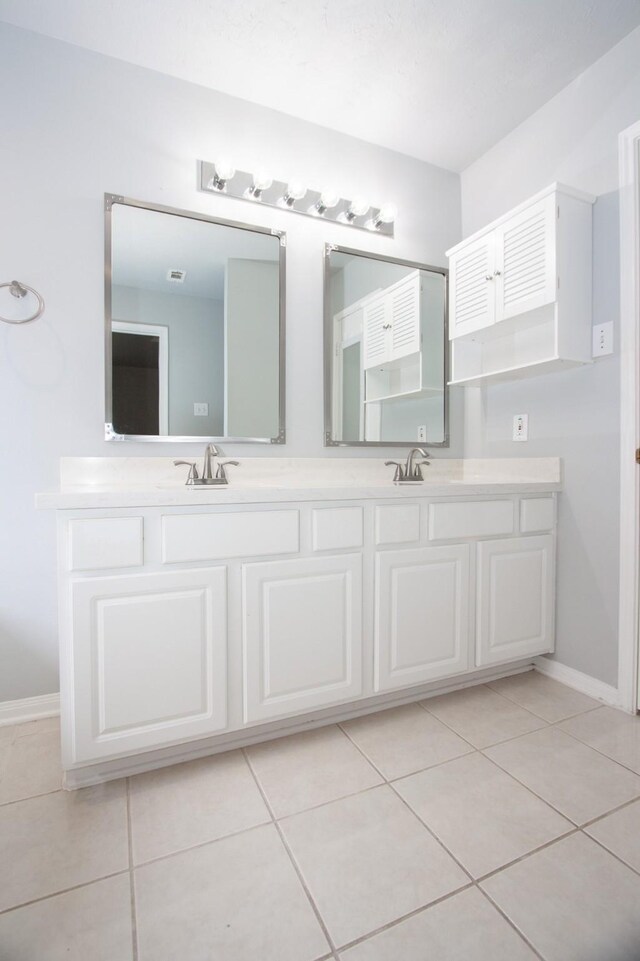 full bathroom featuring double vanity, a sink, and tile patterned flooring