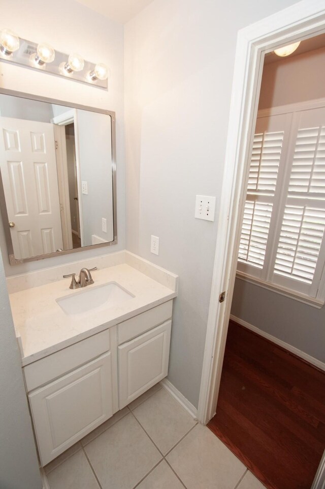 bathroom with baseboards, tile patterned flooring, and vanity