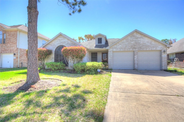 traditional-style home with brick siding, a garage, a front lawn, and driveway