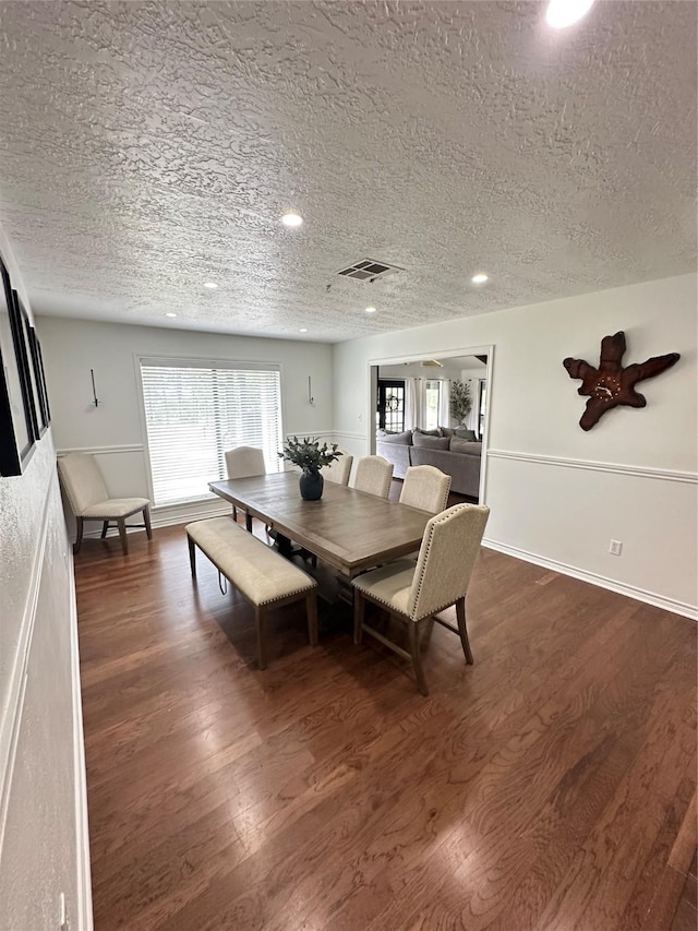 dining area featuring recessed lighting, a textured ceiling, and dark wood finished floors
