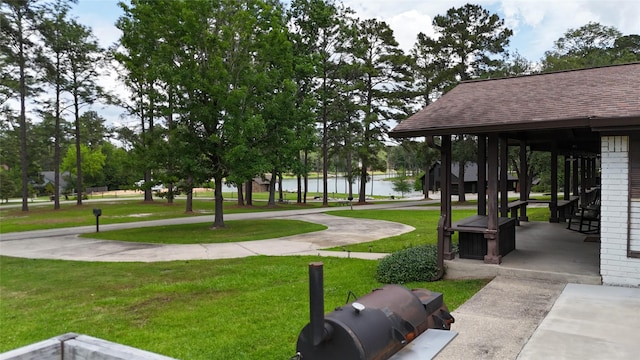 view of community featuring a lawn and a water view