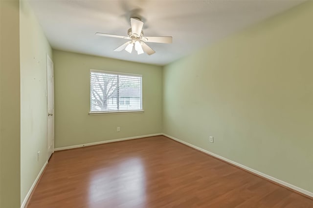 empty room with baseboards, a ceiling fan, and wood finished floors