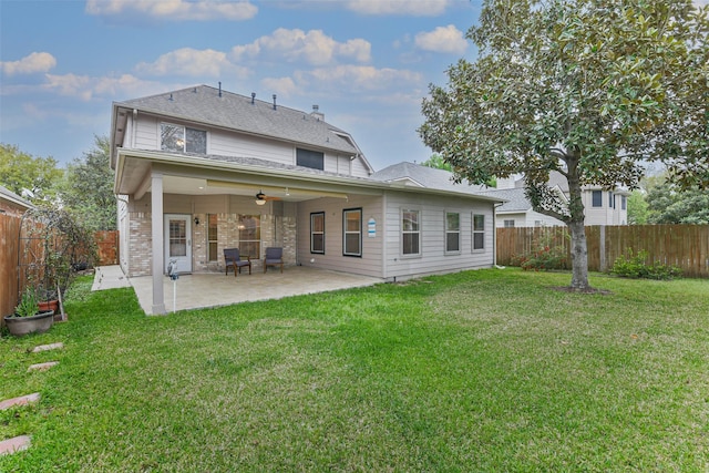 back of property with a lawn, a ceiling fan, a fenced backyard, and a patio area