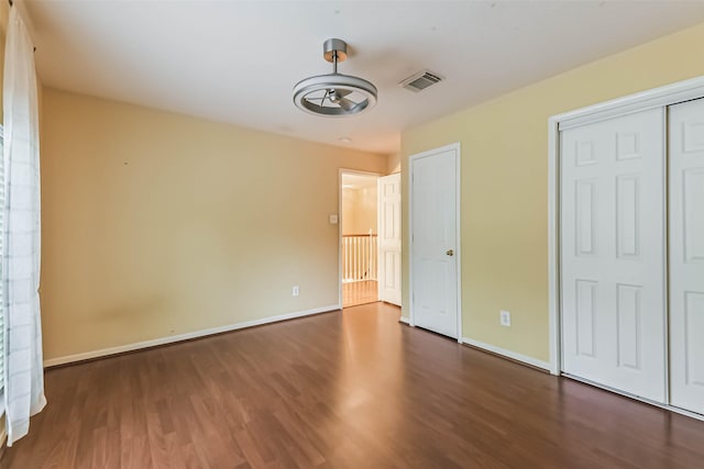 unfurnished bedroom featuring baseboards, visible vents, and wood finished floors