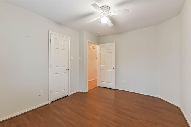 interior space featuring a ceiling fan, baseboards, and wood finished floors