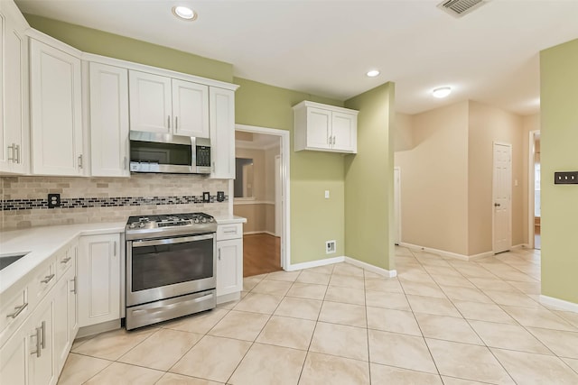 kitchen with visible vents, tasteful backsplash, light countertops, white cabinets, and stainless steel appliances