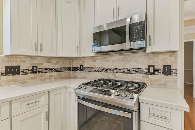 kitchen featuring light countertops, white cabinetry, appliances with stainless steel finishes, and tasteful backsplash