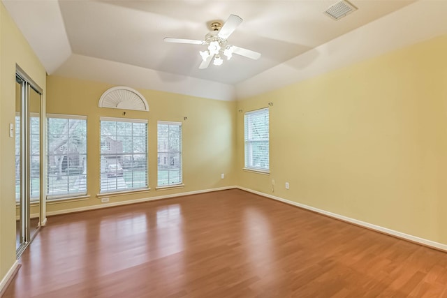 empty room with ceiling fan, visible vents, wood finished floors, and lofted ceiling