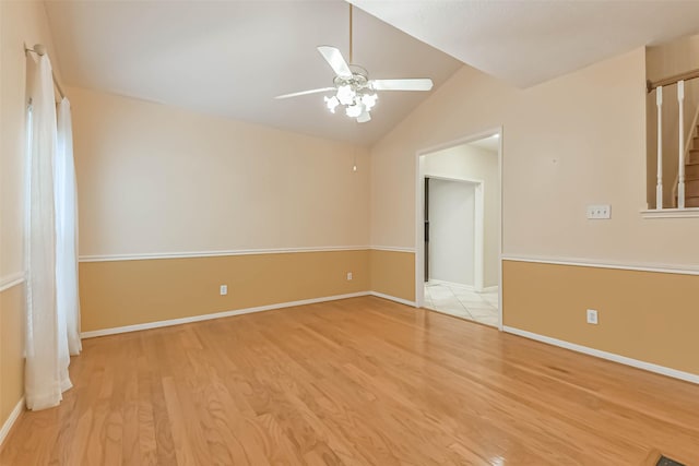 unfurnished room featuring a ceiling fan, baseboards, vaulted ceiling, and wood finished floors