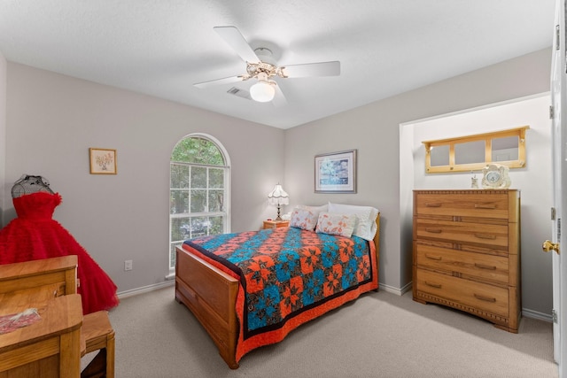 bedroom featuring baseboards, visible vents, a ceiling fan, and light colored carpet