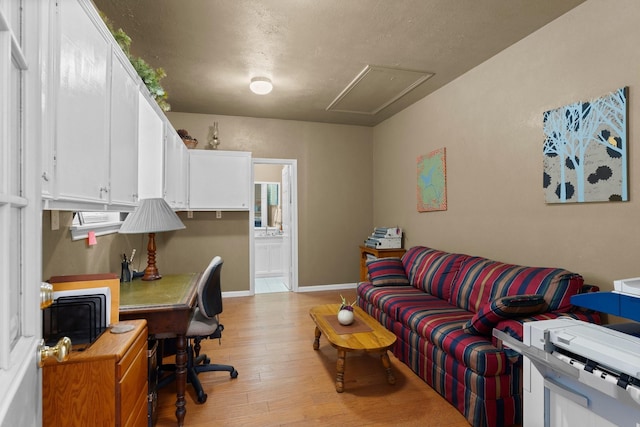 office space with attic access and light wood finished floors