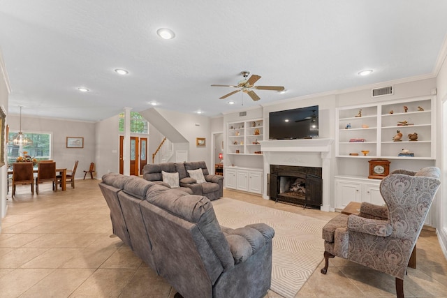 living room featuring stairs, ceiling fan, visible vents, and a healthy amount of sunlight