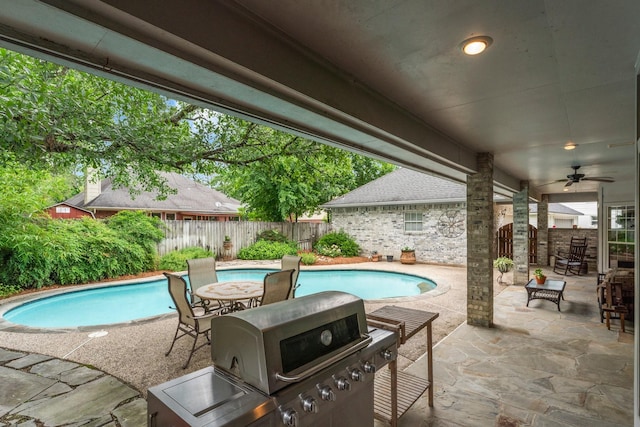 view of pool with ceiling fan, grilling area, a fenced backyard, a fenced in pool, and a patio area