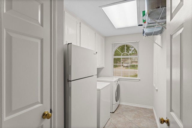clothes washing area with baseboards, light tile patterned flooring, cabinet space, and washer and dryer