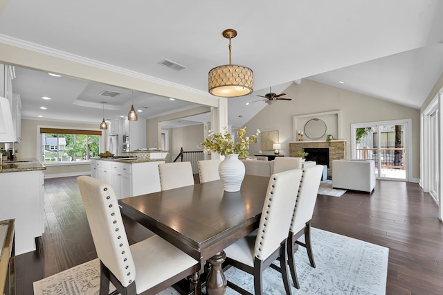 dining room with a ceiling fan, dark wood-style flooring, a fireplace, and visible vents