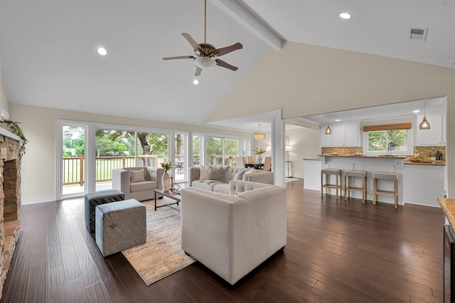 living area with dark wood finished floors, ceiling fan, visible vents, high vaulted ceiling, and beam ceiling