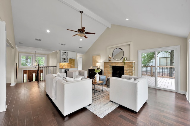 living room with visible vents, ceiling fan with notable chandelier, beamed ceiling, and dark wood-style floors