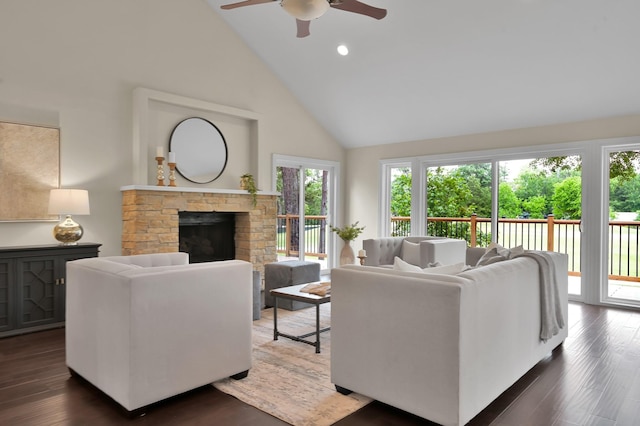 living room featuring ceiling fan, a fireplace, high vaulted ceiling, and dark wood-type flooring