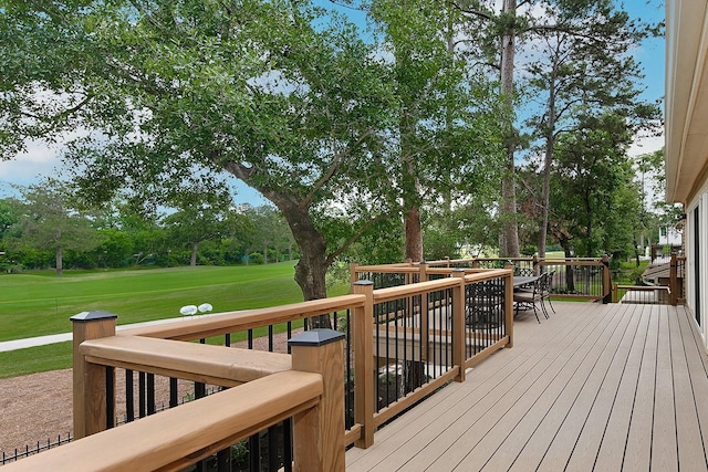 wooden deck with a yard and outdoor dining area
