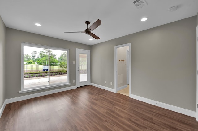 unfurnished room featuring baseboards, visible vents, a ceiling fan, and wood finished floors
