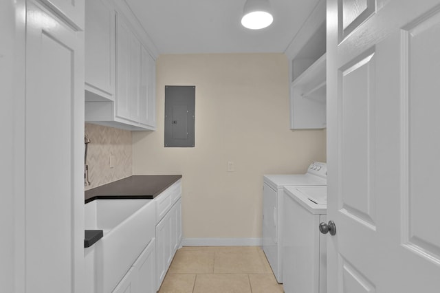 laundry room featuring light tile patterned floors, cabinet space, electric panel, washer and clothes dryer, and baseboards