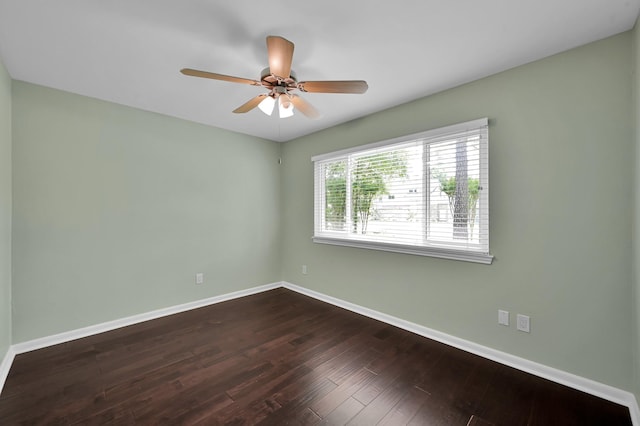 unfurnished room with baseboards, dark wood-style flooring, and ceiling fan