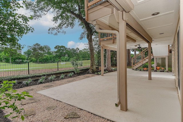 view of patio / terrace with stairway, fence, and a ceiling fan