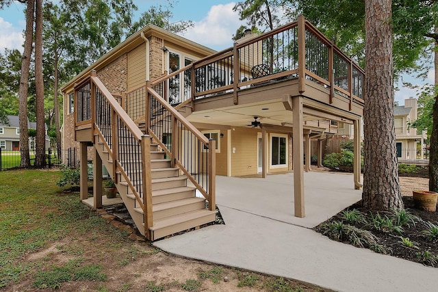 back of property with a patio area, concrete driveway, a deck, stairway, and a carport
