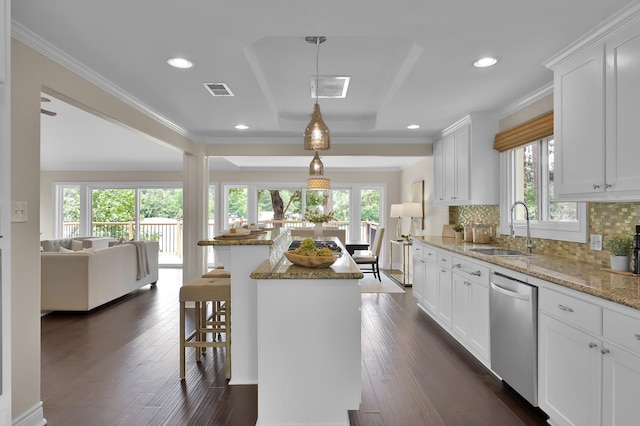 kitchen with dishwasher, a wealth of natural light, a breakfast bar, and a sink