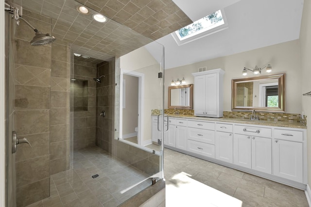 bathroom featuring visible vents, a shower stall, tile patterned floors, double vanity, and a skylight