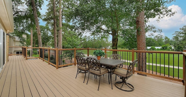 wooden deck with a yard and outdoor dining space