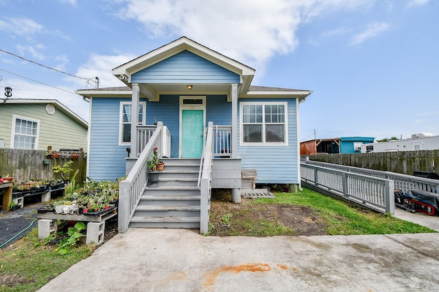 bungalow-style home with fence and covered porch