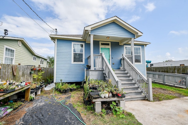 bungalow-style home featuring fence and covered porch