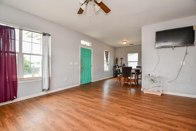 foyer featuring light wood-type flooring, a ceiling fan, baseboards, and a wealth of natural light