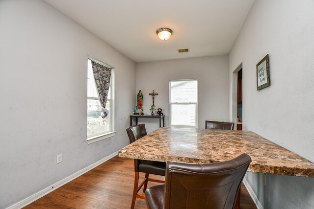 dining area with baseboards, dark wood-style floors, and visible vents