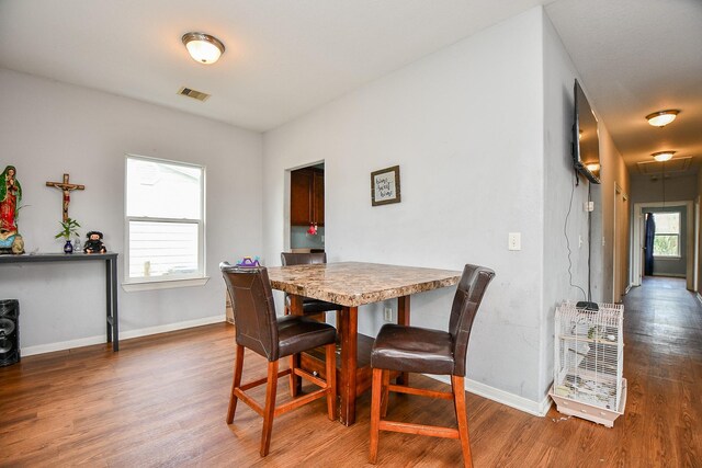 dining space featuring baseboards, visible vents, and wood finished floors