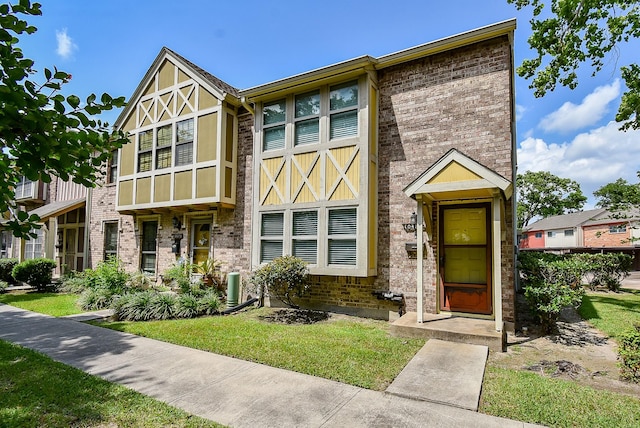 view of front of home with brick siding and a front yard