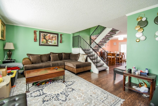 living room with stairs, a textured ceiling, ornamental molding, and wood finished floors