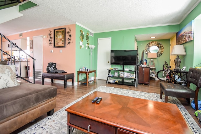 living area featuring crown molding, stairs, a textured ceiling, and wood finished floors