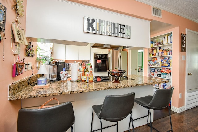 kitchen featuring crown molding, a peninsula, visible vents, dark wood-style floors, and black appliances